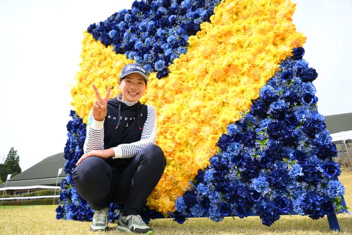 “Vポイント”のロゴの前でVサイン。菅楓華がツアー初戦を鹿児島で迎える。